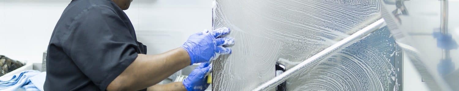 A closeup shot of a hospital cook in black uniform disinfecting hospital kitchen