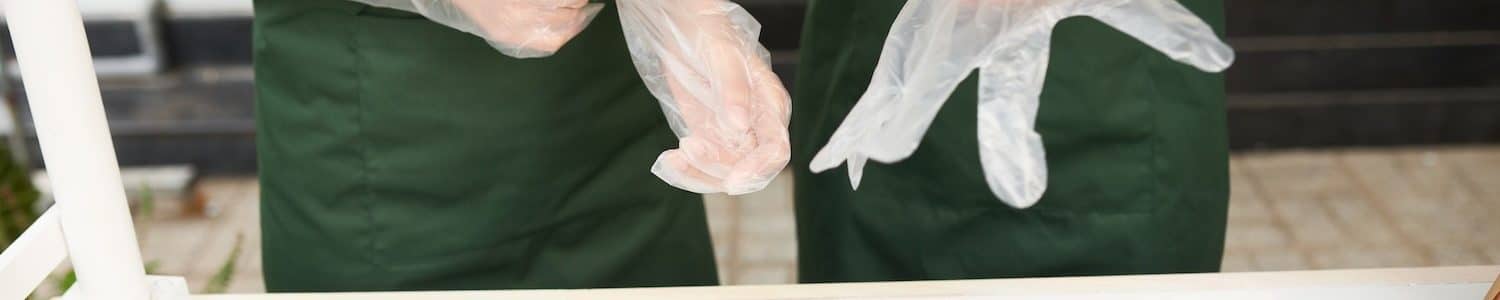 Food cart vendors putting on disposable gloves to make sandwiches for customers